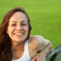 Beautiful woman smiling and looking straight to camera at park